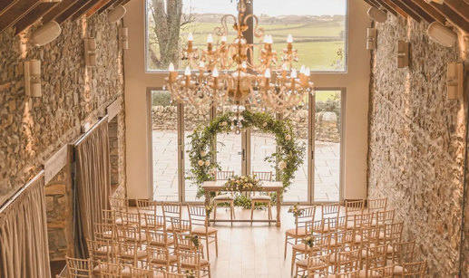 overhead view of ceremony space with circular green arch at the top of the aisle and two sides of rows of wooden chairs