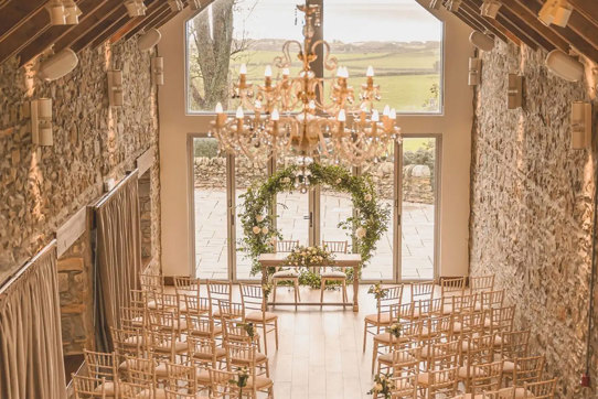 overhead view of ceremony space with circular green arch at the top of the aisle and two sides of rows of wooden chairs