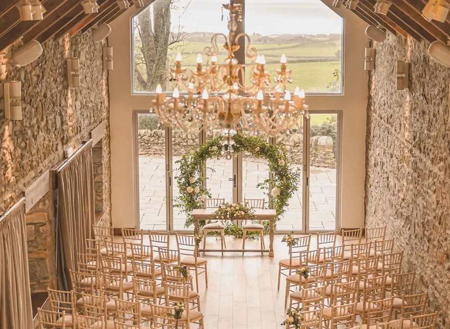 overhead view of ceremony space with circular green arch at the top of the aisle and two sides of rows of wooden chairs