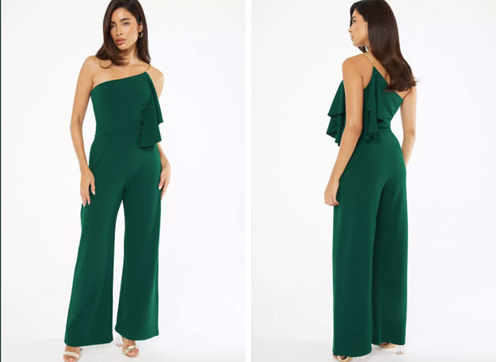 A woman wearing a dark green one shoulder jumpsuit