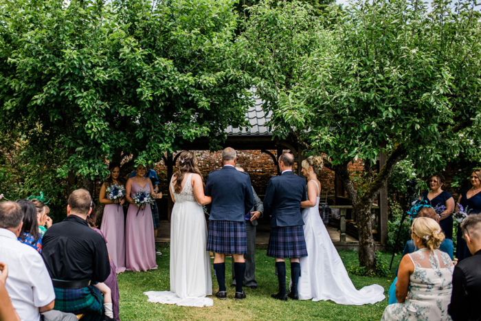 Brides and their fathers at the top of the aisle