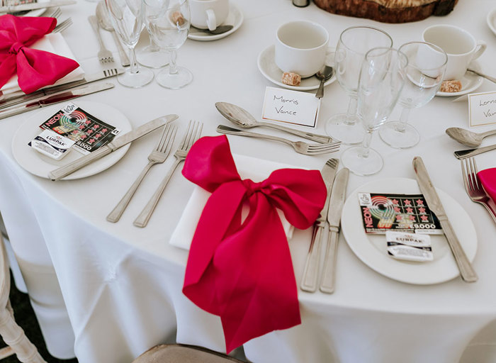 large red bow at a wedding table place setting