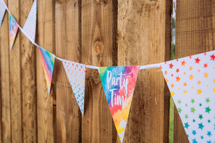 Colourful Party Time Bunting Against A Wooden Fence