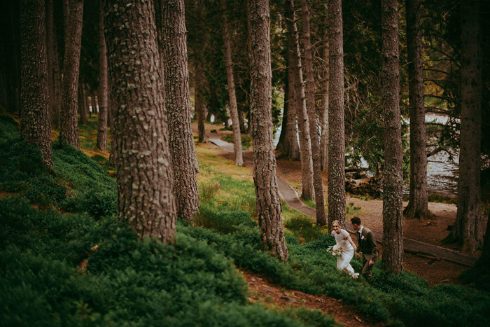 bride and groom walking through woods near mar lodge