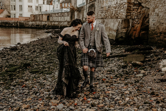 Bride and groom have couple photos taken by the water