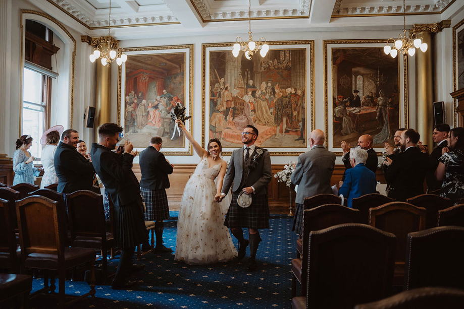 Couple cheer as they leave their ceremony