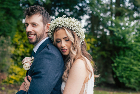 Bride cuddles into groom during couple portrait