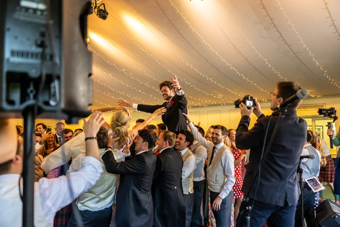 Bride and groom are lifted by their guests