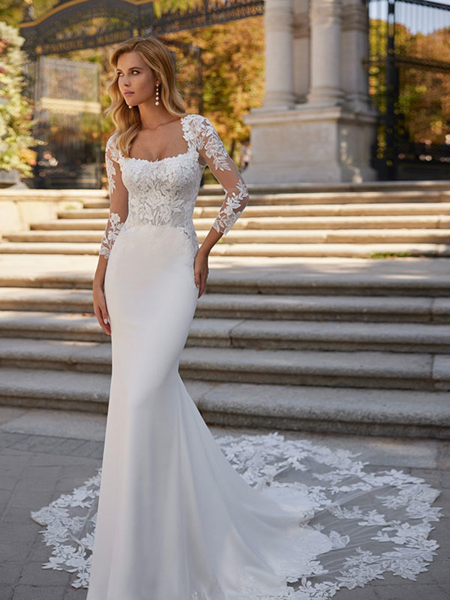 woman wearing long trailing mermaid wedding dress complete with lace sleeves