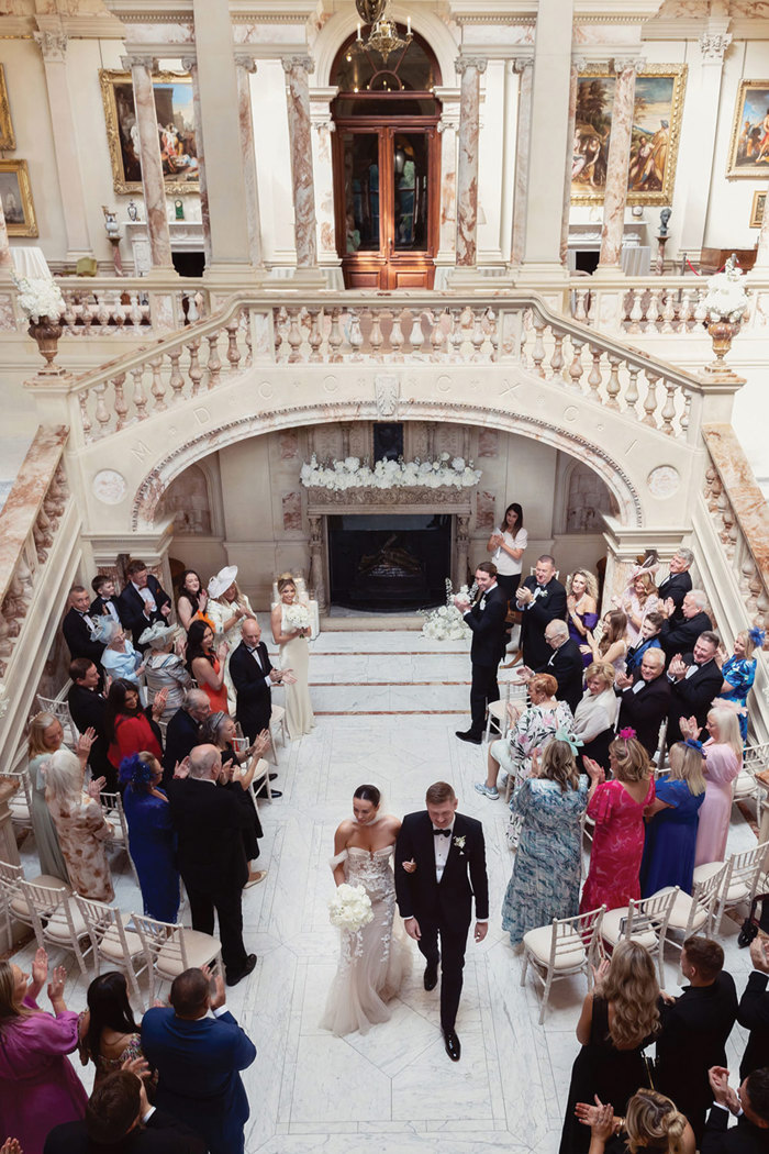 A bride and groom walking down the aisle at Gosford House.