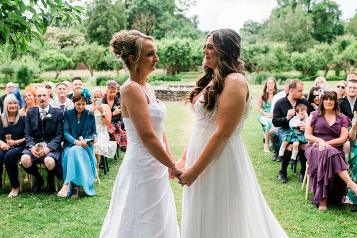 Brides hold hands during their ceremony