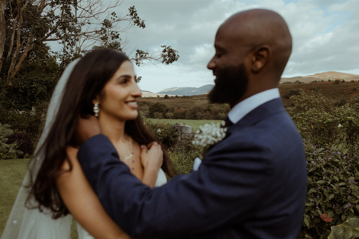 A Bride And Groom Embracing with arran countryside in background