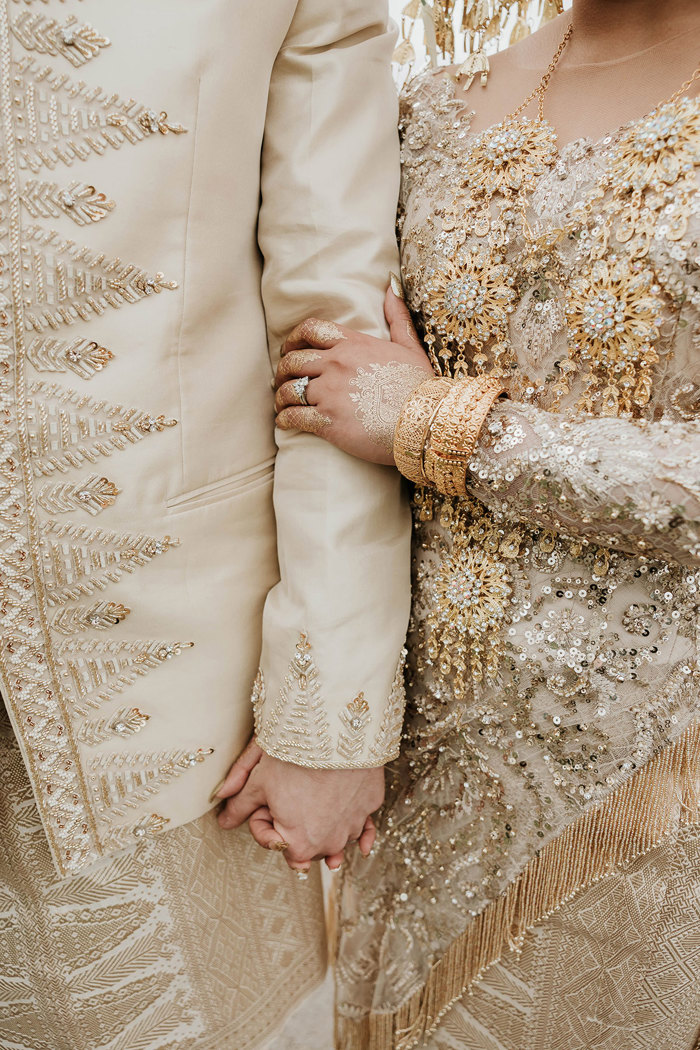 close up details bride and groom walking through edinburgh with indonesian wedding outfits