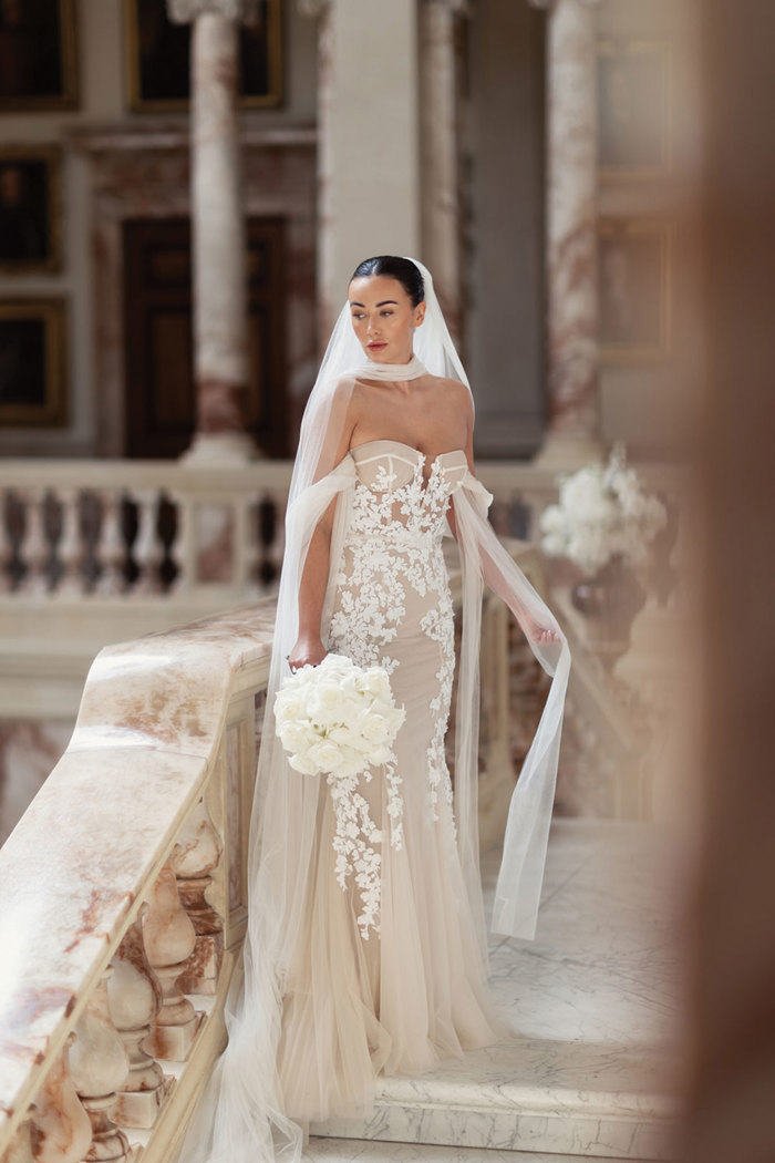 A bride standing on a marble staircase.