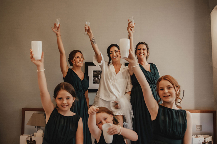 Bride and bridesmaids raise their glasses 