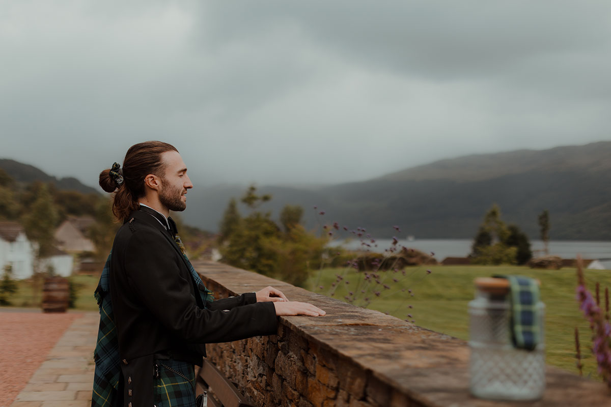 a groom looking out onto Loch Goil at Carrick Castle Estate wedding 