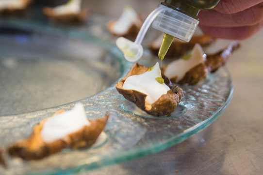 Decorating canapes with bottle of oil 