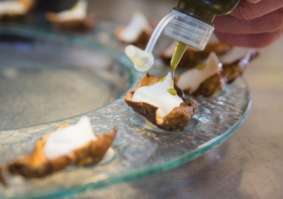 Decorating canapes with bottle of oil 