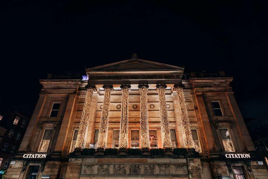 Citation Glasgow exterior of the venue lit up in the evening with fairy lights on columns 