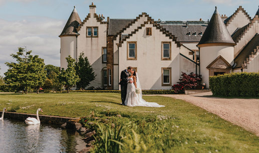 Couple kiss in front of Ingliston Estate and Country Club