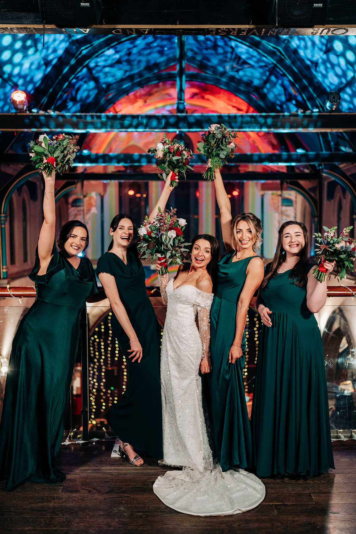 bride smiles next to her bridesmaids wearing green dresses at oran mor