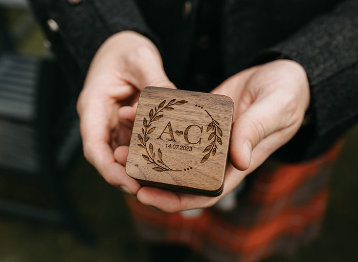 A small wooden box with a leaf design and a carving that says 'A ❤️C 14.07.2023' 