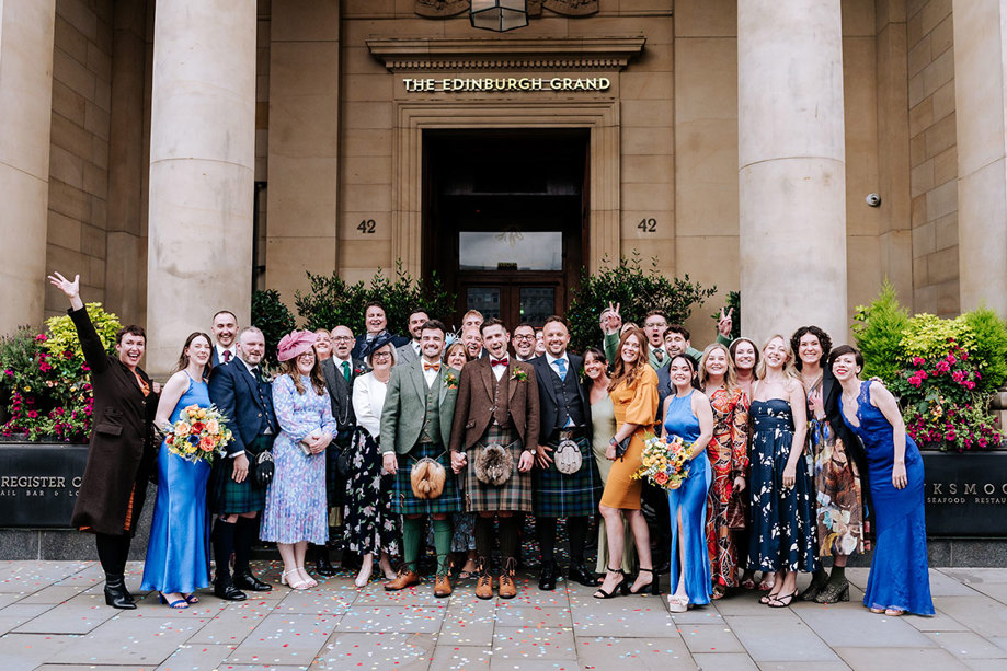 A group of people posing for a photo in front of a building, Cheval The Edinburgh Grand.