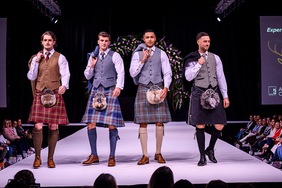 four men in kilts on the catwalk at the Scottish Wedding Show