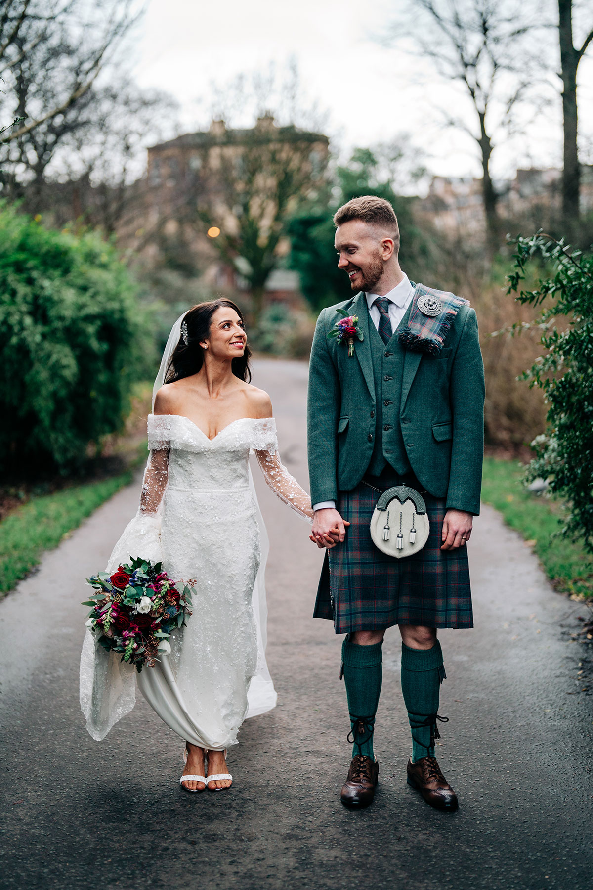 bride and groom smile at one another and hold hands in glasgow