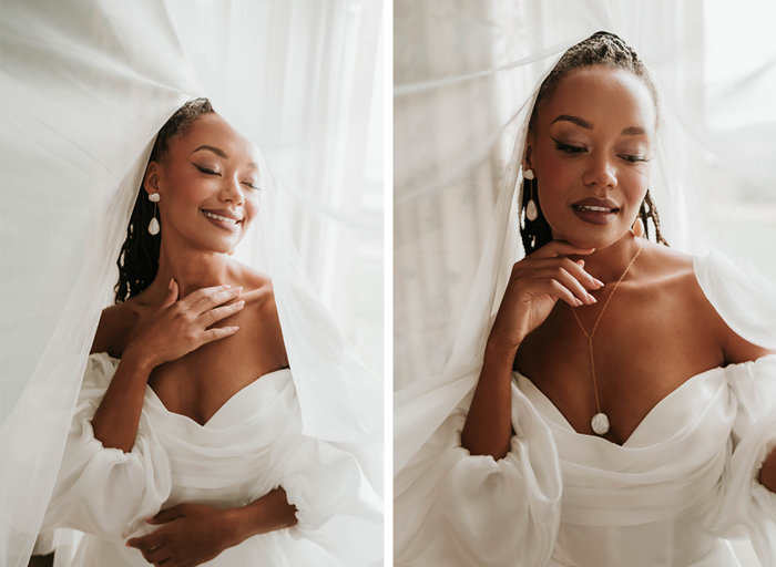 Bride posing in wedding gown, underneath the cover of her long veil