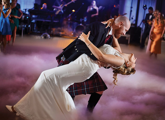 Bride and groom dancing surrounded by smoke