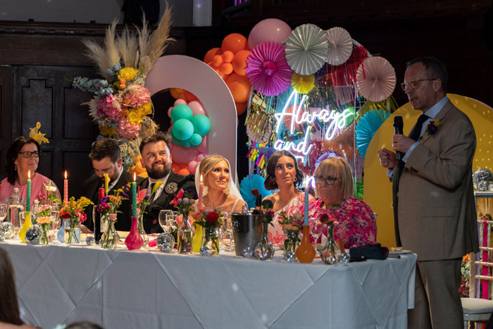 Top table look at bride's dad making his speech during wedding breakfast