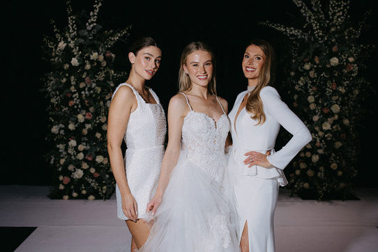 A group of women in white dresses on the catwalk at the Scottish Wedding Show.