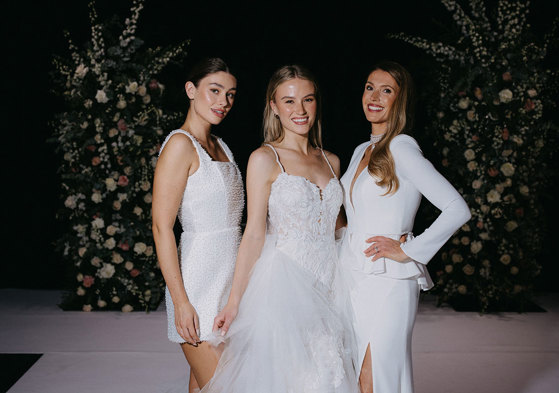 A group of women in white dresses on the catwalk at the Scottish Wedding Show.