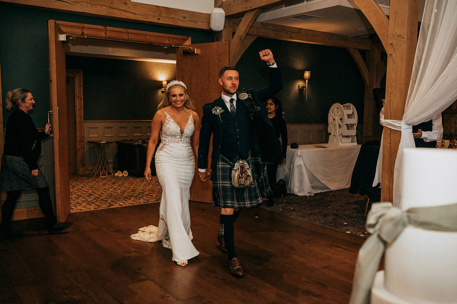 Groom raises a fist as the happy couple enter Enterkine House hand in hand