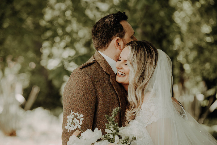 Bride and groom smile during couple portrait