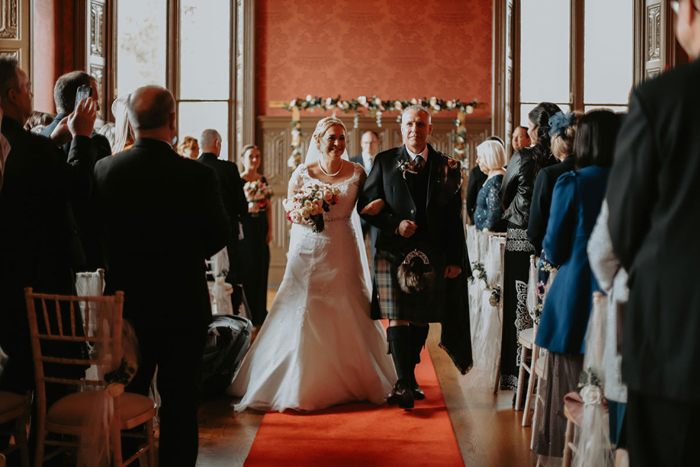 Bride and groom walk up the aisle as newlyweds