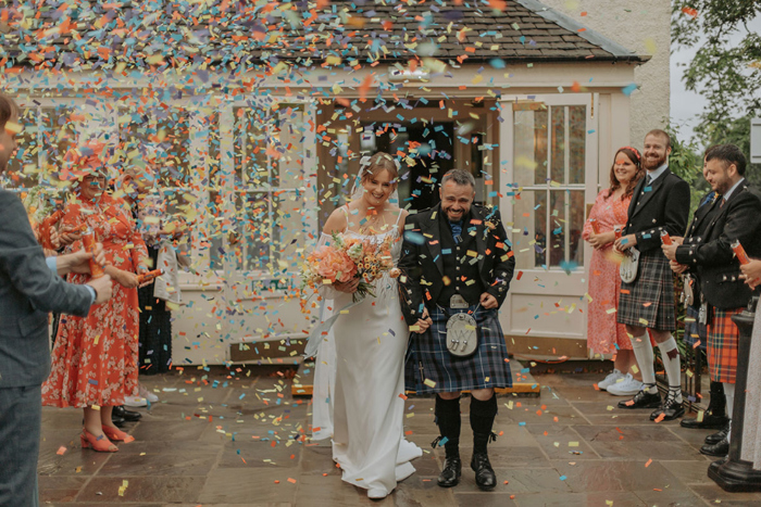 Couple walk through confetti shower