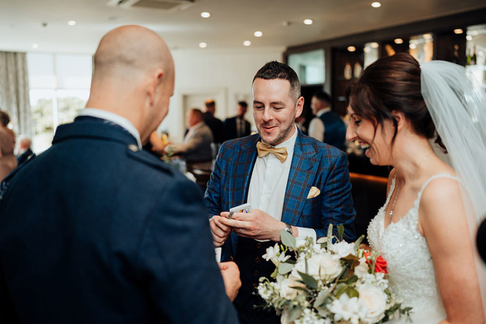 Magician Billy Reid performing a card trick for a bride and groom at Seamill Hydro