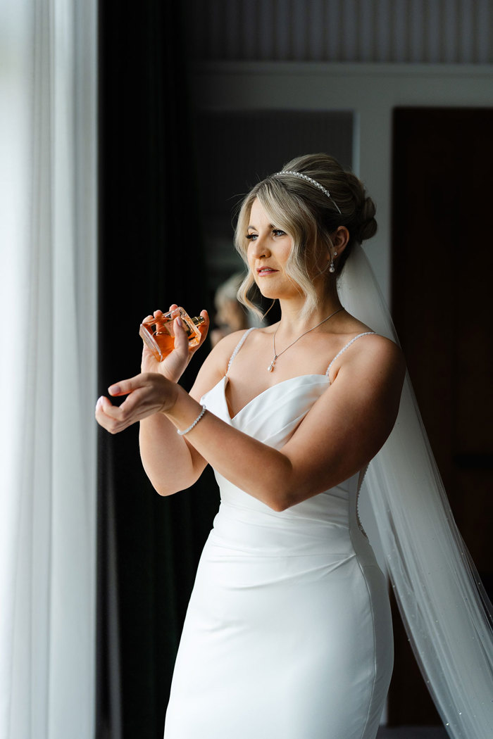 a bride holding a perfume bottle.