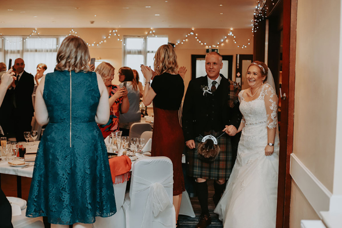 Happy couple entering their wedding reception