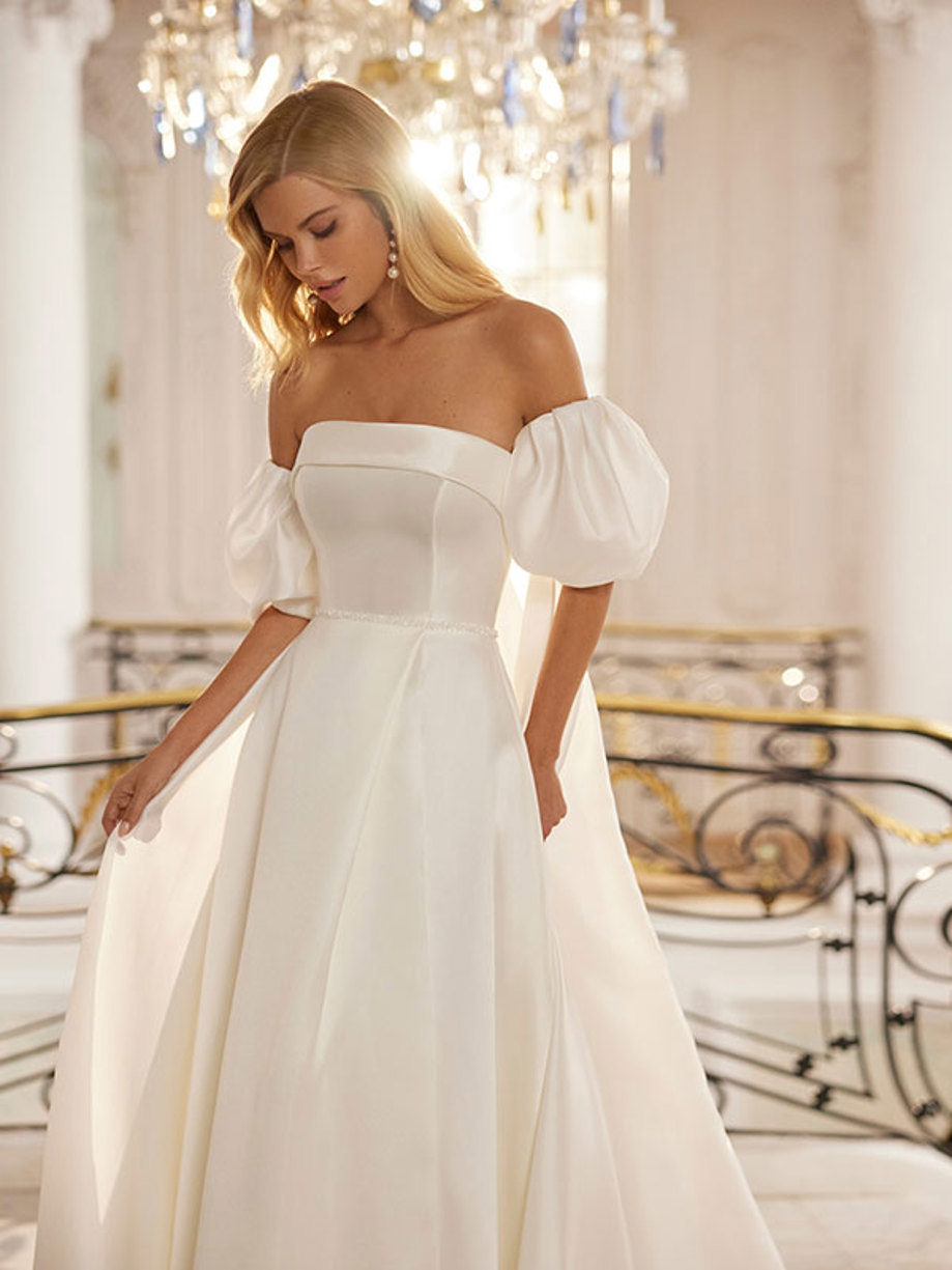 woman wears long wedding dress with strapless neckline and short detachable puff sleeves 