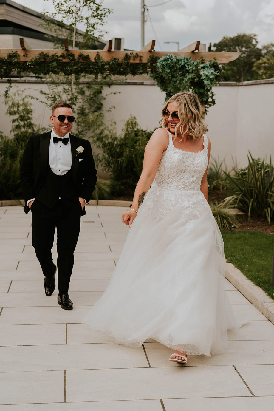 A bride and groom walking in the Garden House at the Redhurst Hotel