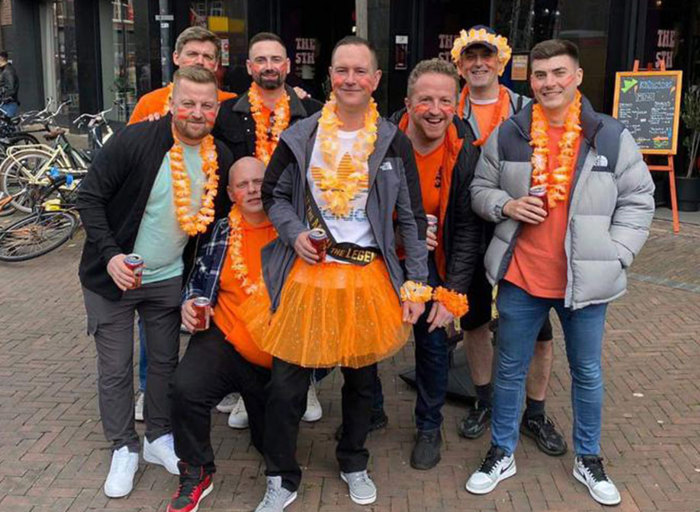 Group of men wearing bright orange accessories and clothes