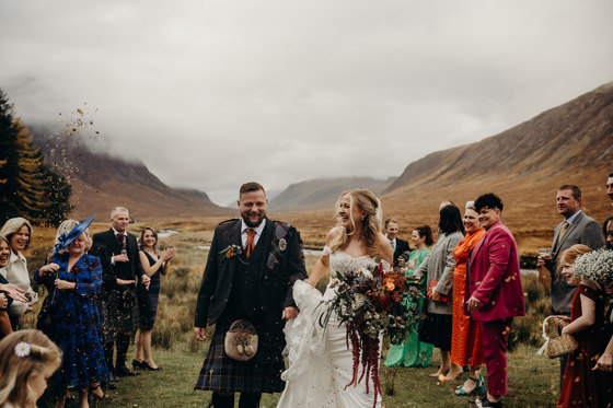 Bride and groom confetti shot in Scottish Highlands with mist-covered hills in background
