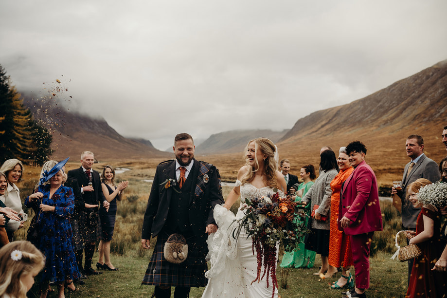 Bride and groom confetti shot in Scottish Highlands with mist-covered hills in background