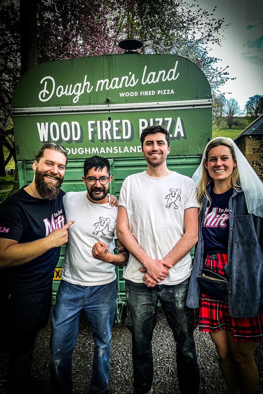 Bride, groom and owners of Dough Man's Land smile in front of horsebox