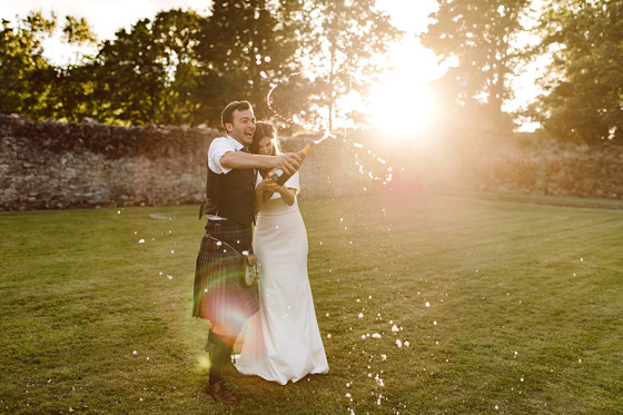 Bride and groom laugh as champagne sprays