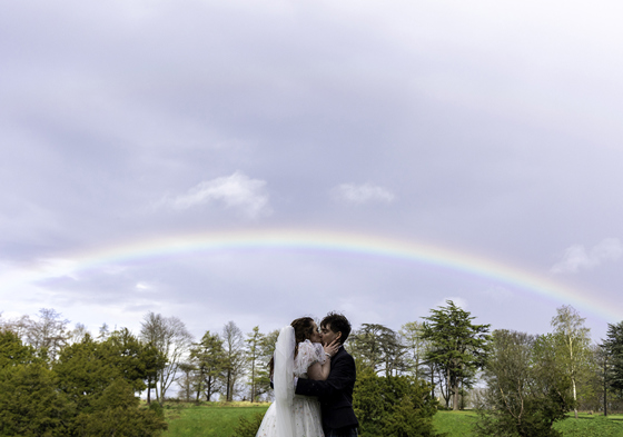 Newlyweds kiss under rainbow