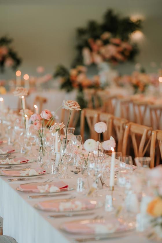 Long tables with pink floral decor and white candles